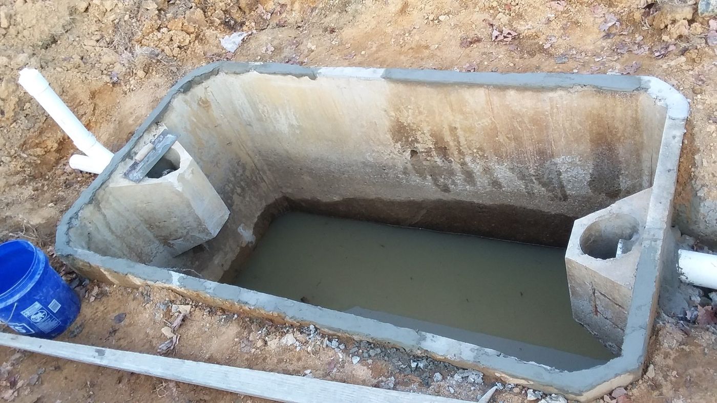 Concrete septic tank set in an excavation